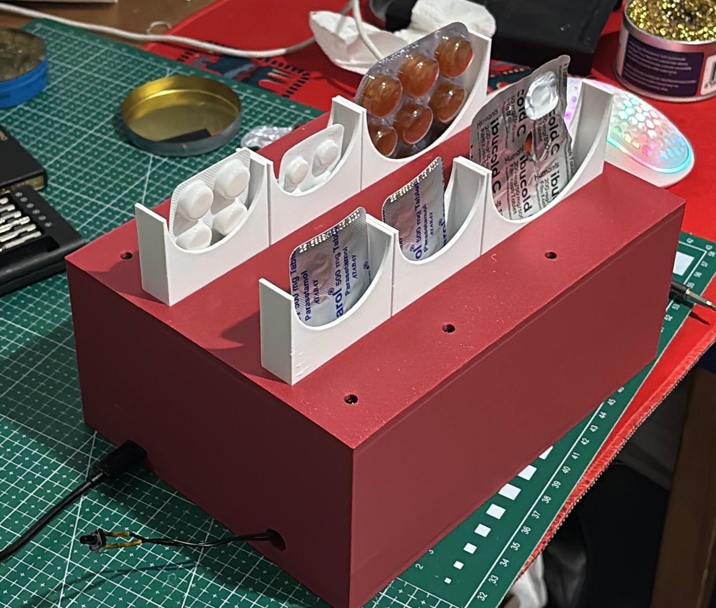 Smart Pill Tracker: 3D-printed red enclosure with six blister-pack compartments